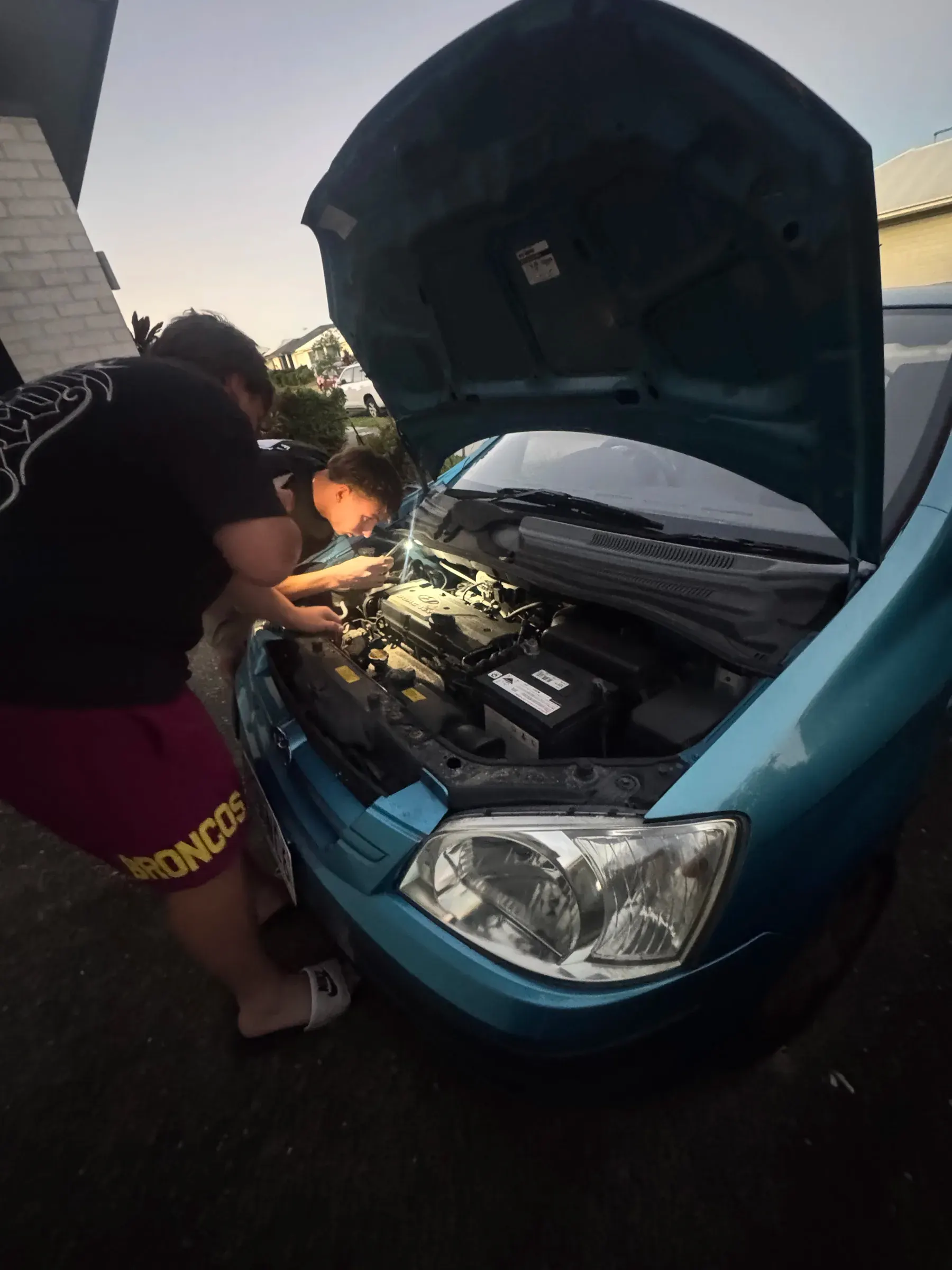 Mechanic inspecting a client's engine bay before a cash offer